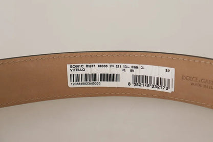 حزام دولتشي آند غابانا من الجلد الأسود مع مشبك معدني ذهبي محفور عليه شعار